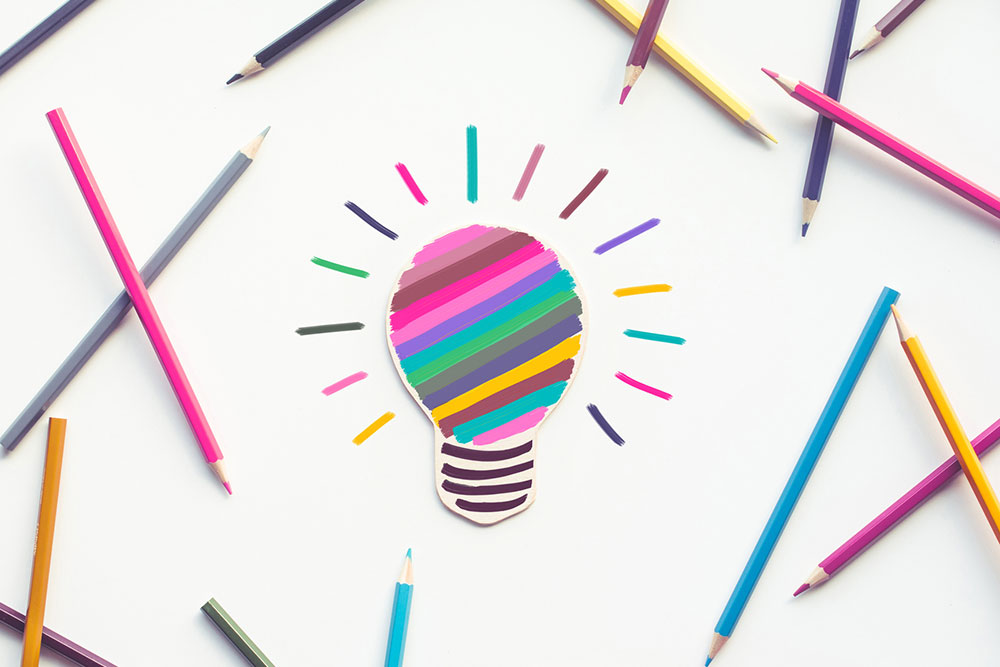 Group-of-colorful-pencil-with-light-bulb-painting-on-white